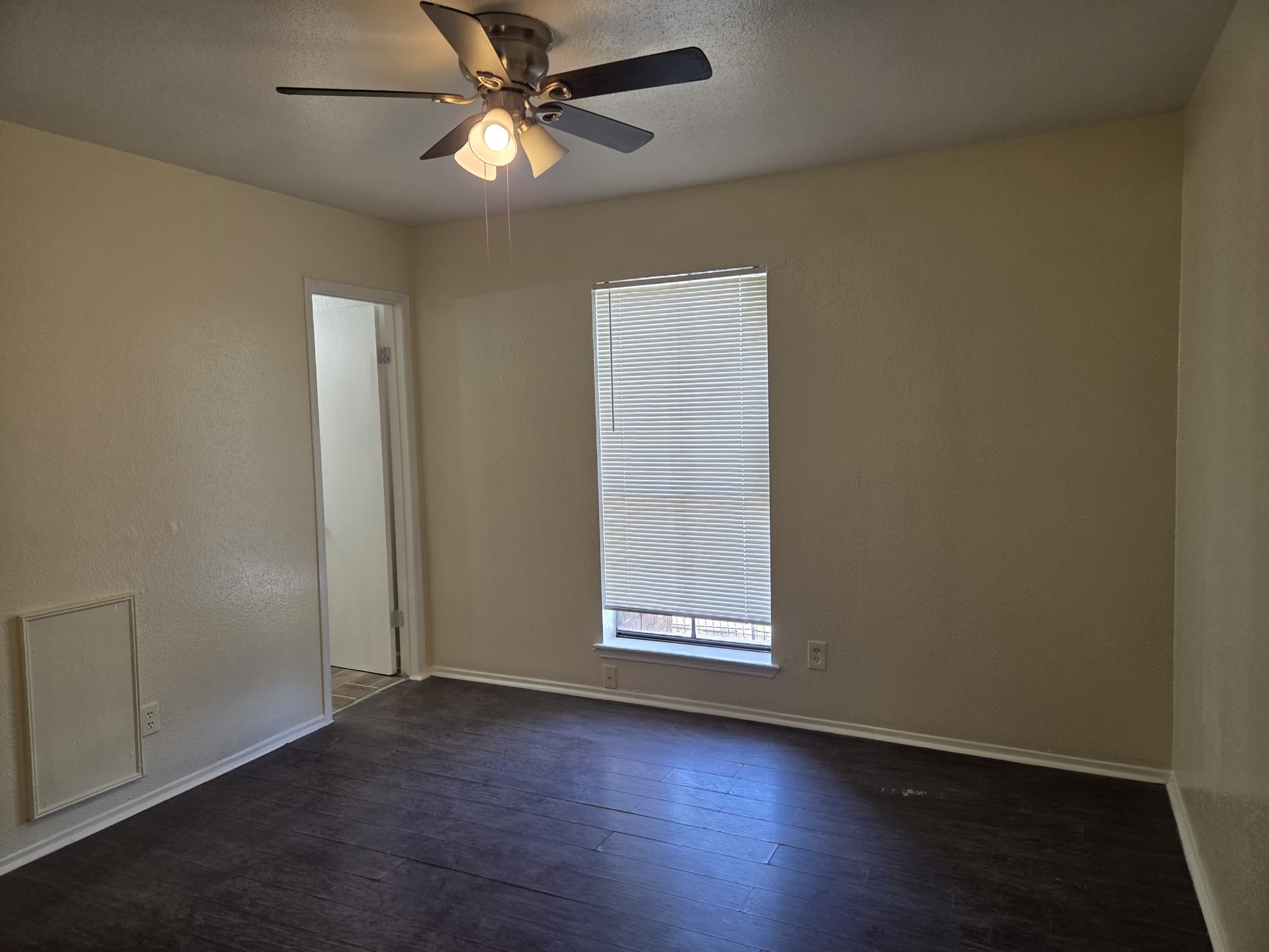 11549 South Kirkwood Road Houston, TX 77099 - Photo 3 of 7 an empty room with wooden floor fan and windows