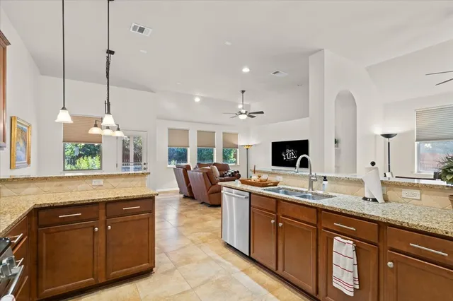a large kitchen with kitchen island granite countertop a sink and a wooden floor