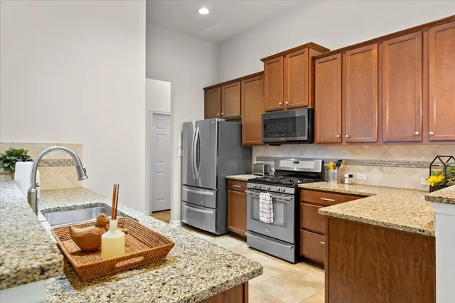 a kitchen with stainless steel appliances granite countertop a stove refrigerator sink and microwave
