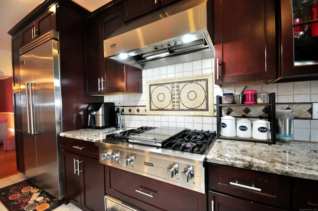 a kitchen with stainless steel appliances granite countertop a stove and a refrigerator