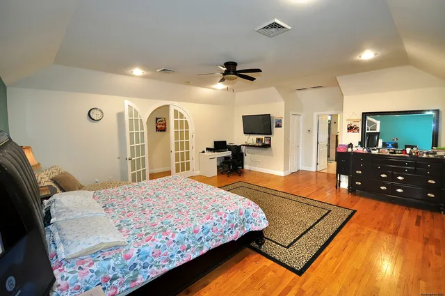 a bedroom with a bed dresser and a flat screen tv