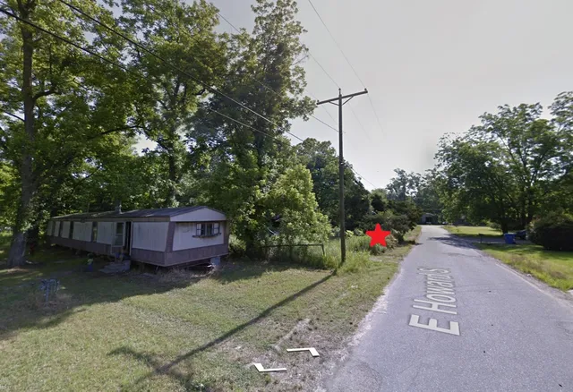 a view of a house with a yard and hanging chair