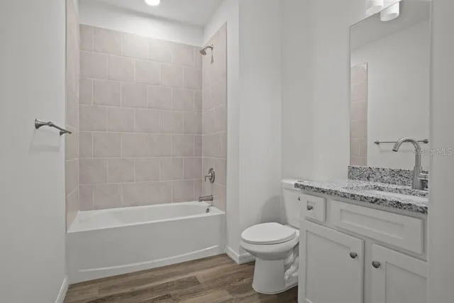 a bathroom with a granite countertop toilet a sink and bathtub