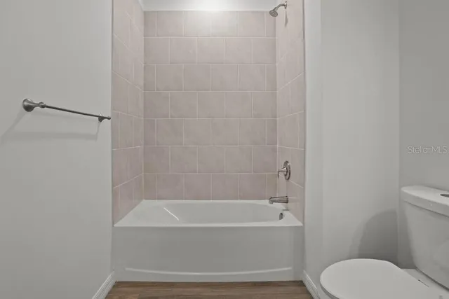 a bathroom with a toilet and a bath tub