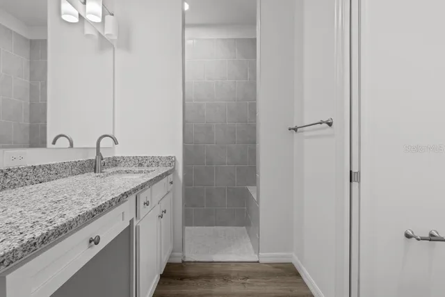 a bathroom with a granite countertop sink and a mirror