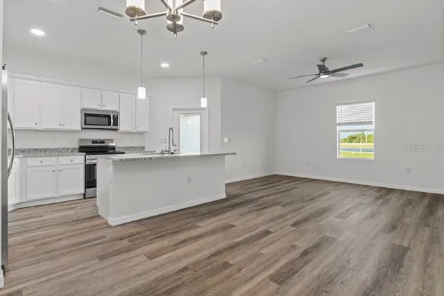 a view of kitchen with granite countertop cabinets and wooden floor