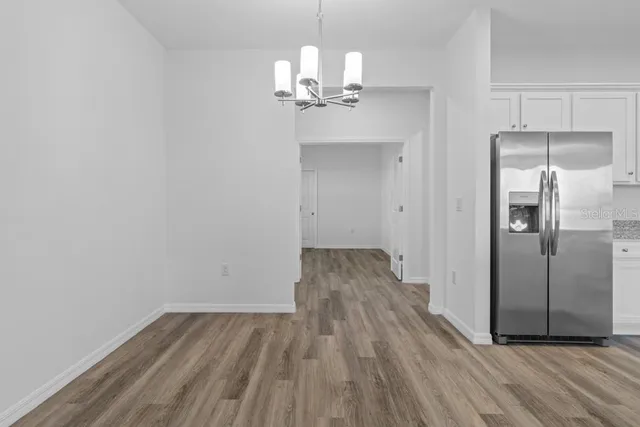 a view of a kitchen with wooden floor and a ceiling fan