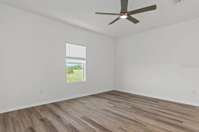 wooden floor in an empty room with a window