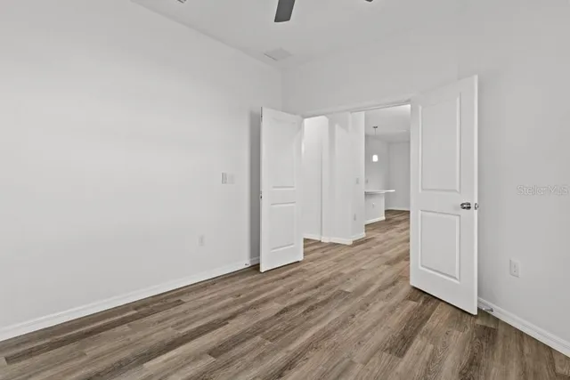 a view of an empty room with wooden floor