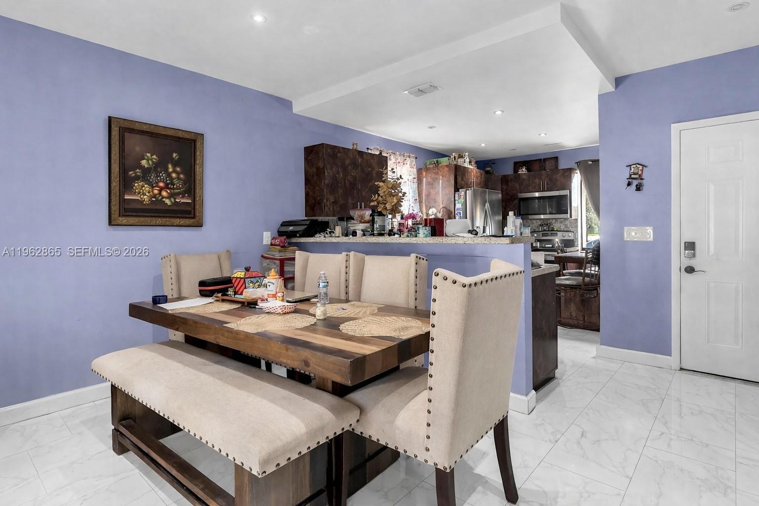 12201 Southwest 194th Terrace Miami, FL 33177 - Photo 17 of 34 a kitchen with a stove a refrigerator and a dining table