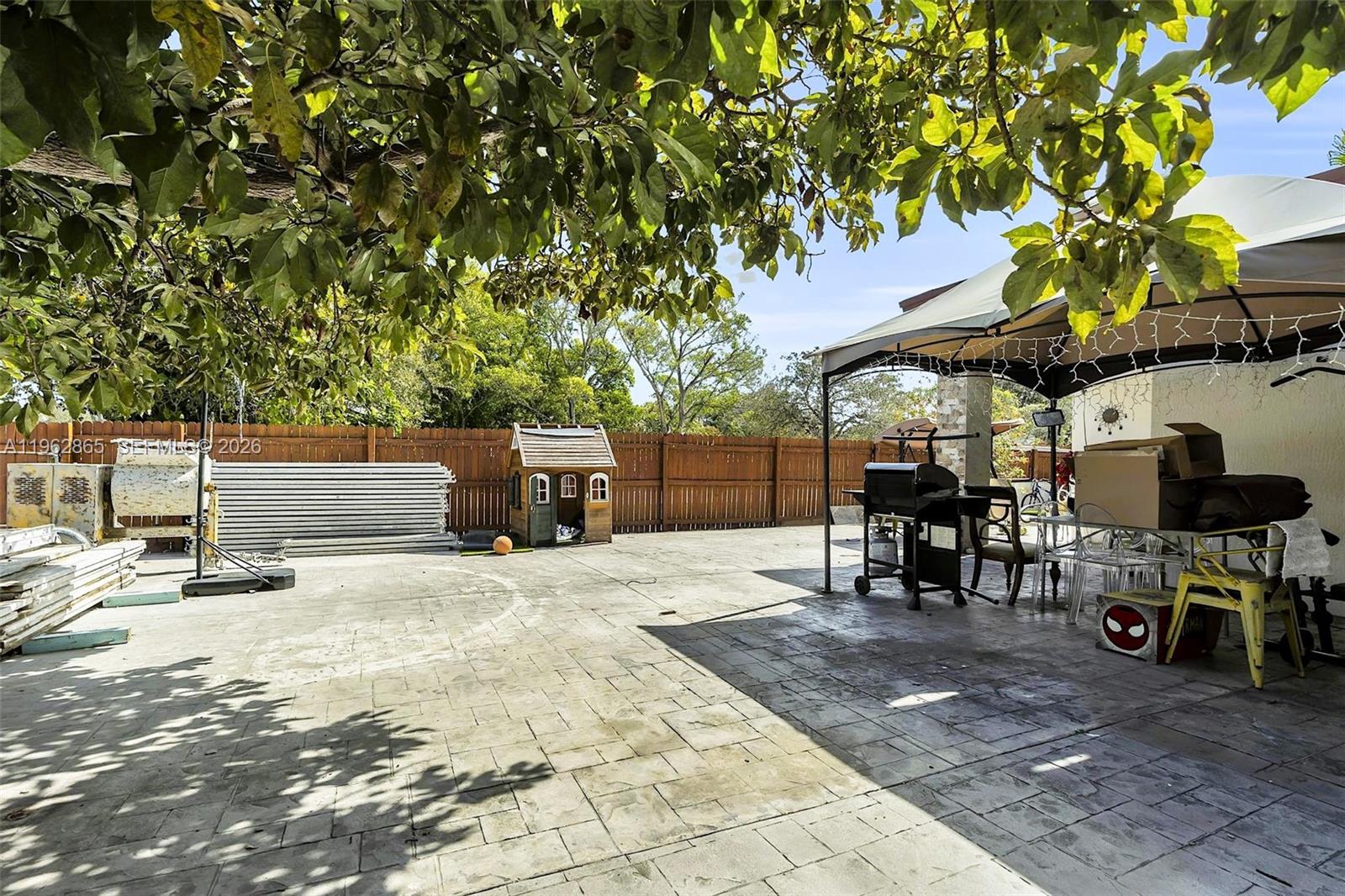 12201 Southwest 194th Terrace Miami, FL 33177 - Photo 29 of 34 a view of backyard with a table and chairs under an umbrella