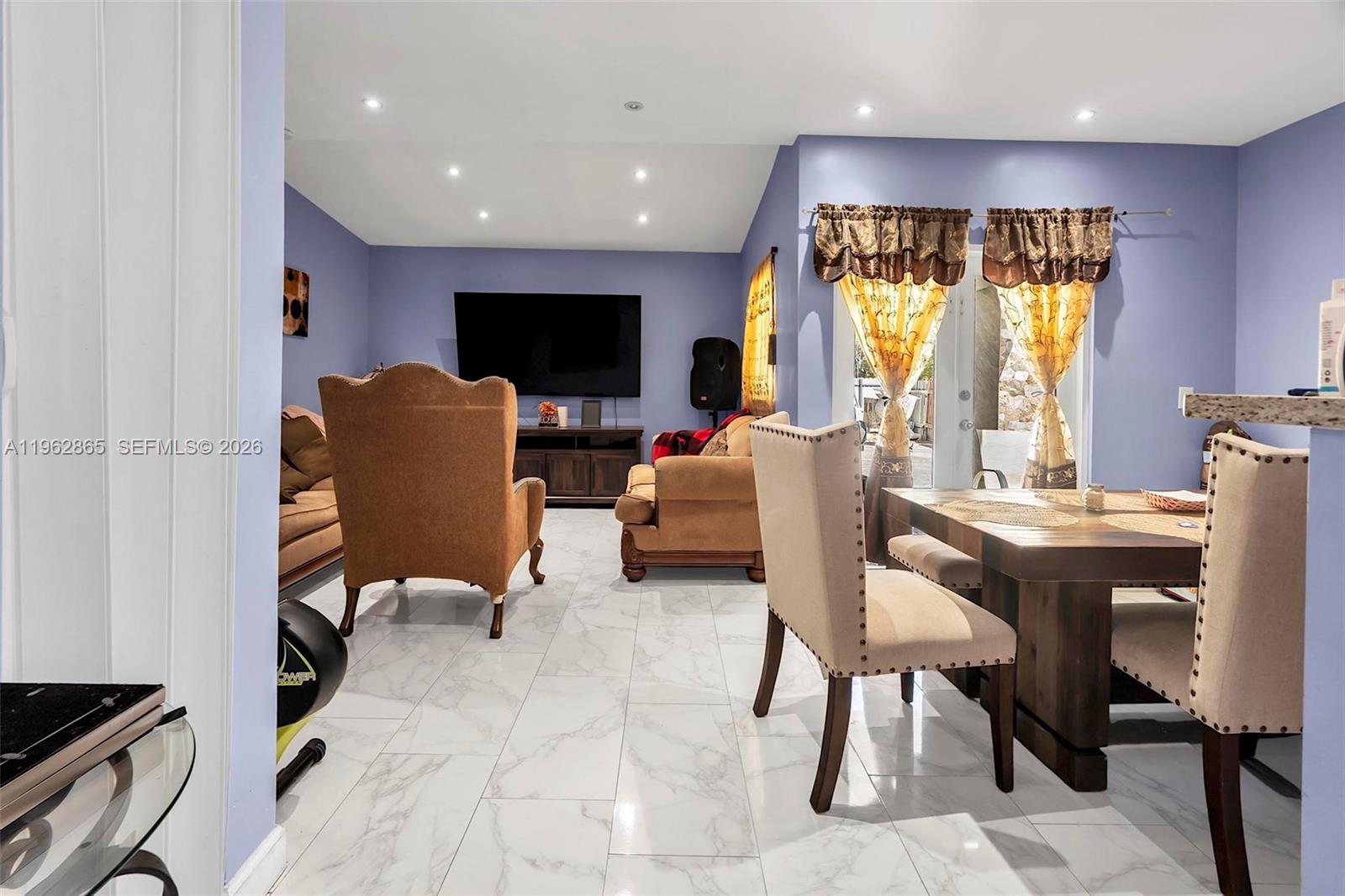 12201 Southwest 194th Terrace Miami, FL 33177 - Photo 4 of 34 a living room with furniture a flat screen tv and a large window