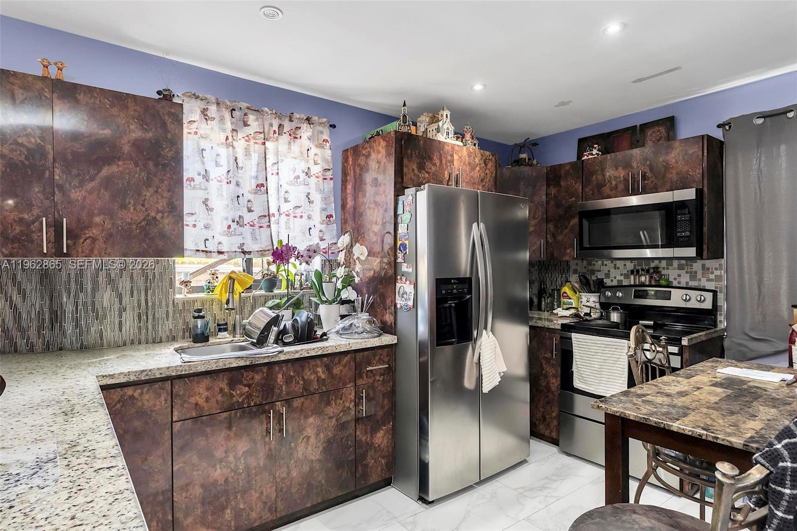 12201 Southwest 194th Terrace Miami, FL 33177 - Photo 7 of 34 a kitchen with a refrigerator and a stove