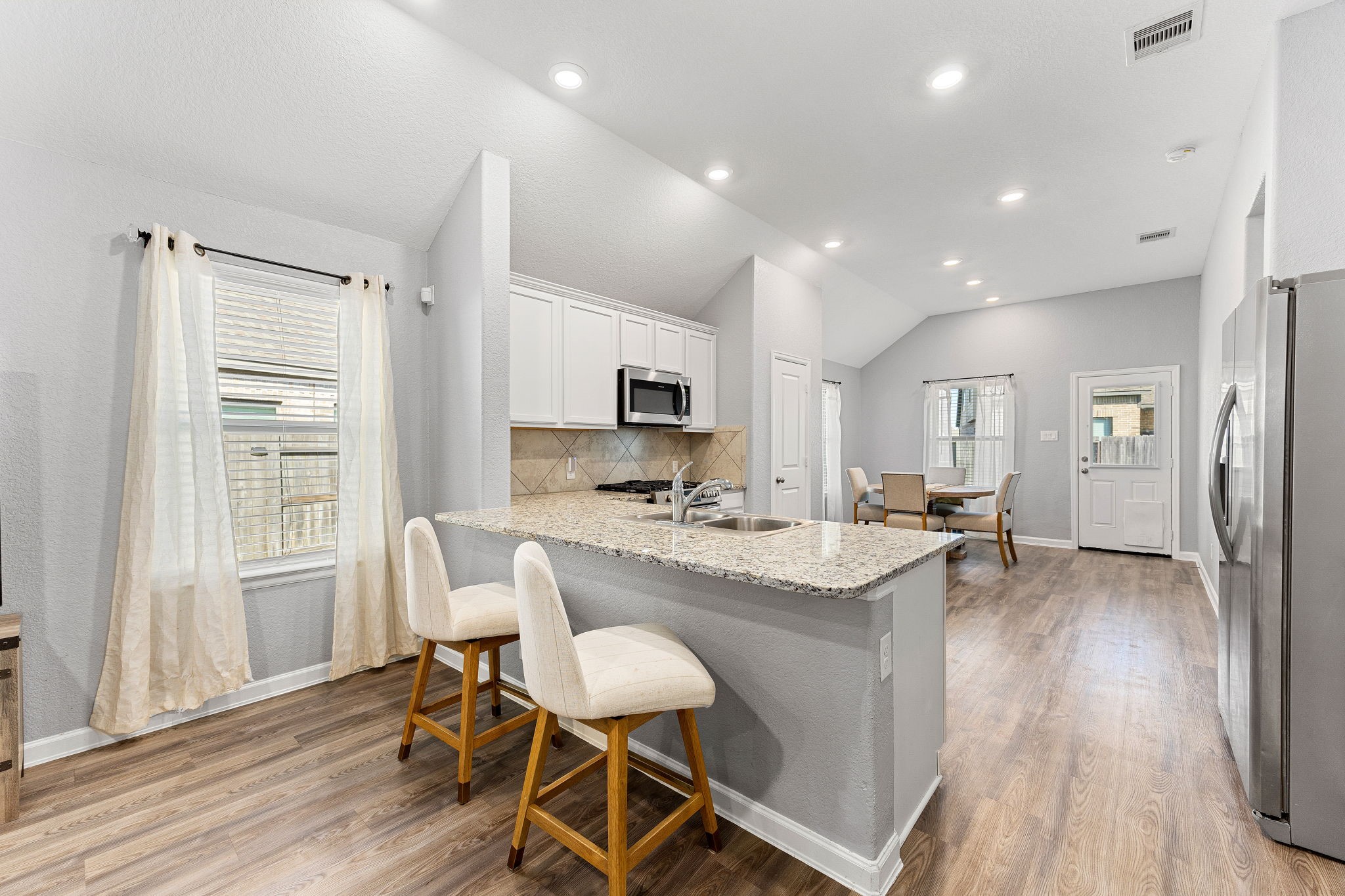 23002 Blackstone Park Road Katy, TX 77493 - Photo 9 of 36 a kitchen with a table chairs refrigerator and cabinets