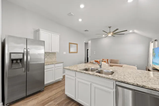 a kitchen with stainless steel appliances granite countertop a sink stove and refrigerator