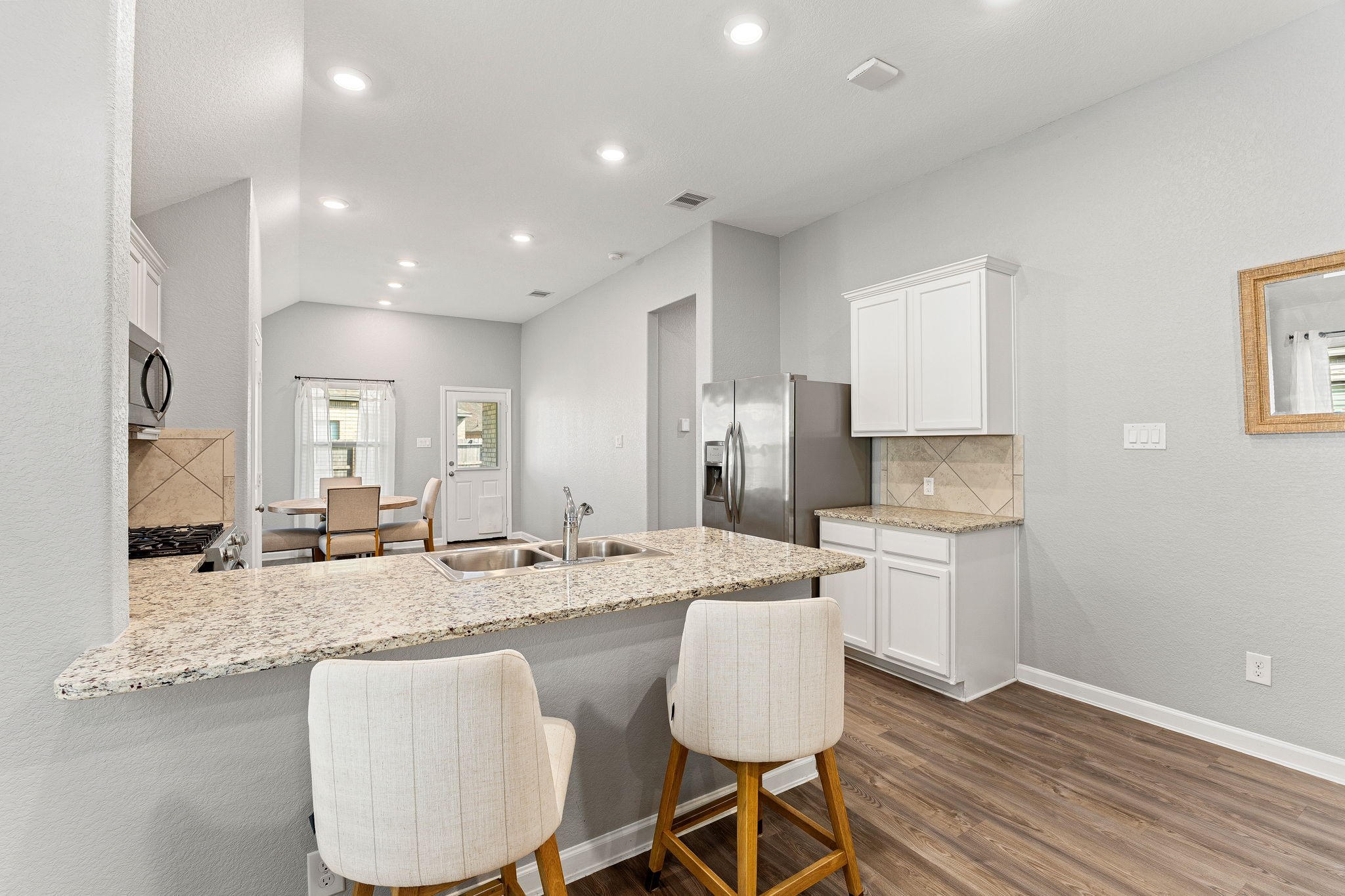 23002 Blackstone Park Road Katy, TX 77493 - Photo 13 of 36 a open kitchen with granite countertop a sink and white cabinets