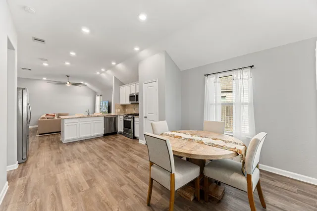 a open kitchen with granite countertop a sink and white cabinets