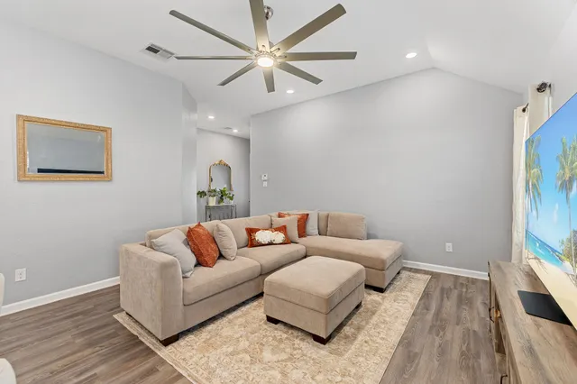 a living room with furniture and a wooden floor