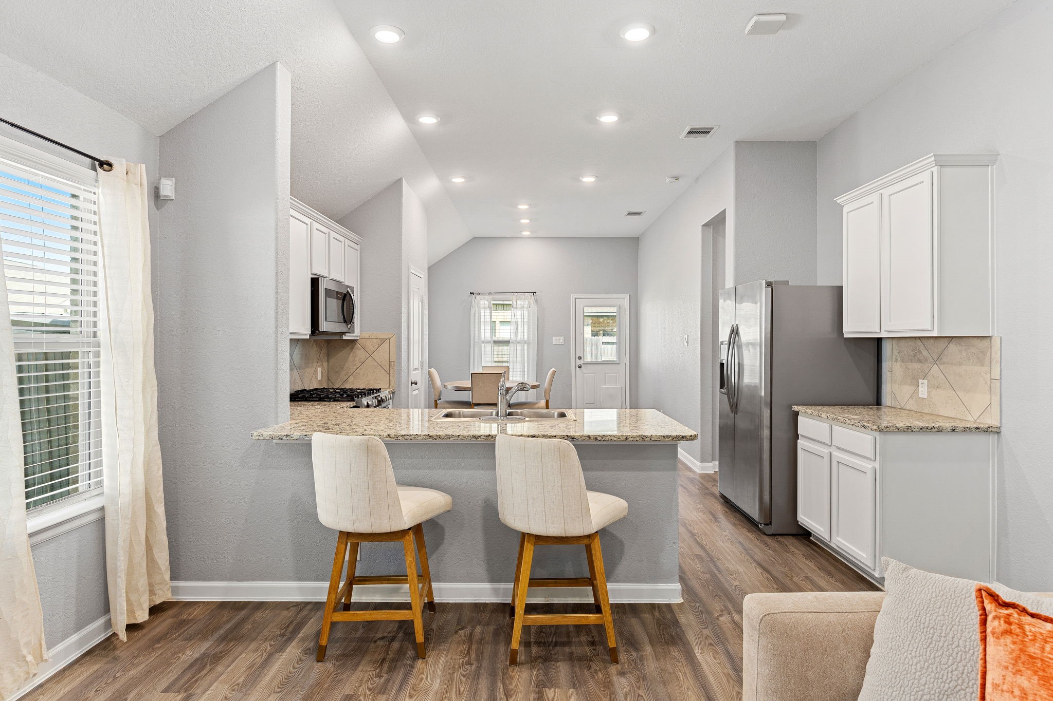 23002 Blackstone Park Road Katy, TX 77493 - Photo 8 of 36 a kitchen with stainless steel appliances kitchen island granite countertop a dining table chairs and a refrigerator