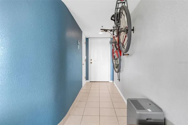 a view of a brick house with plants and large trees