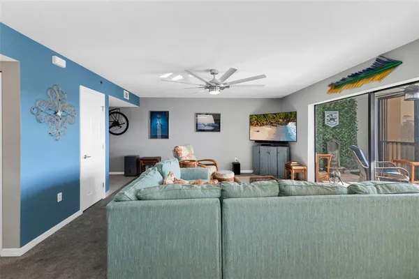 a living room with furniture a flat screen tv and a large window
