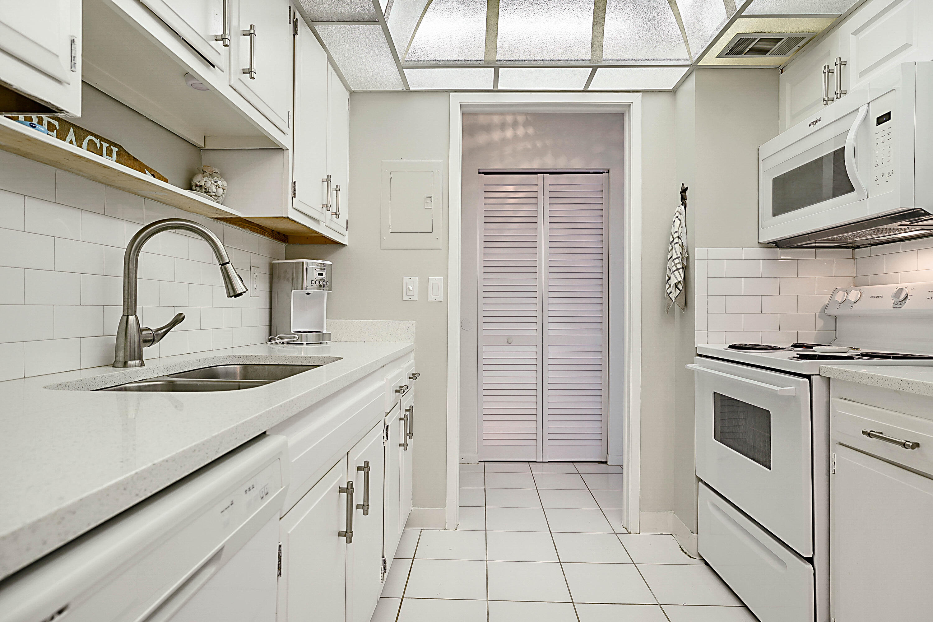 2121 North Ocean Boulevard, Unit 407W Boca Raton, FL 33431 - Photo 15 of 60 a kitchen with stainless steel appliances a sink stove and cabinets