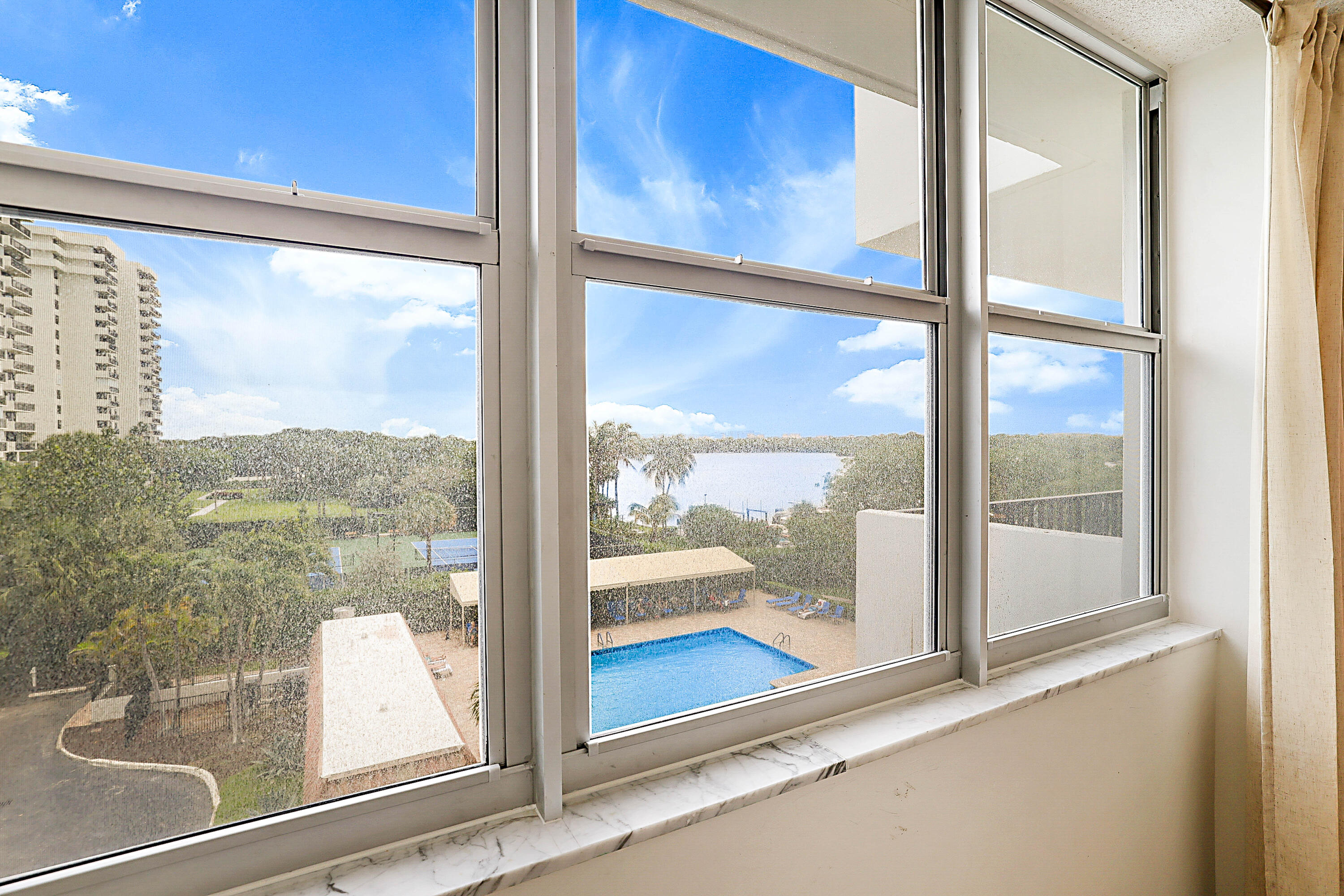 2121 North Ocean Boulevard, Unit 407W Boca Raton, FL 33431 - Photo 23 of 60 a view of a glass door with a flat screen tv