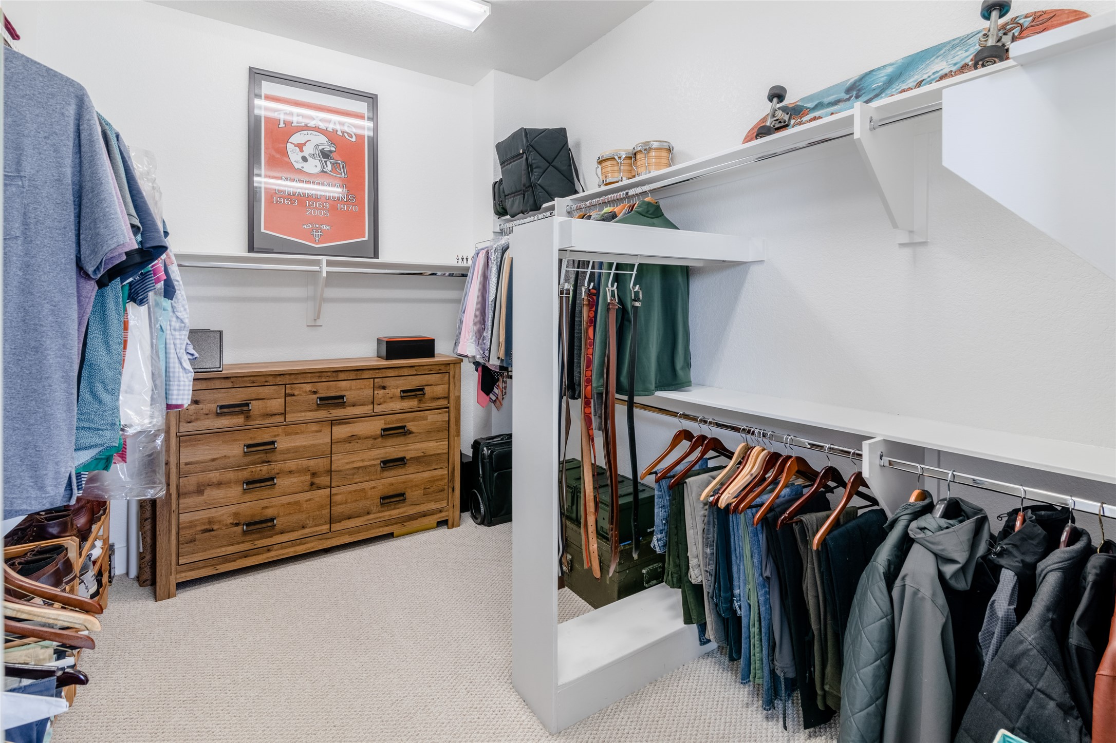 6025 Seville Drive Austin, TX 78724 - Photo 21 of 40 1 of 2 spacious primary walk-in closet featuring built-in shelving, multiple hanging rods