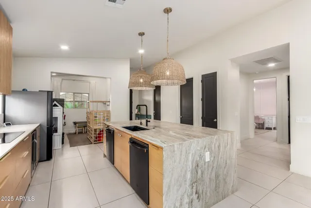 a large kitchen with stainless steel appliances a stove a sink a oven and a refrigerator