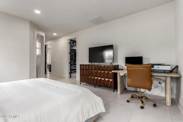 a bedroom with a bed and a flat screen tv