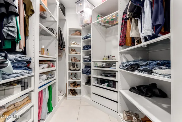 a view of walk in closet with clothes and shoes
