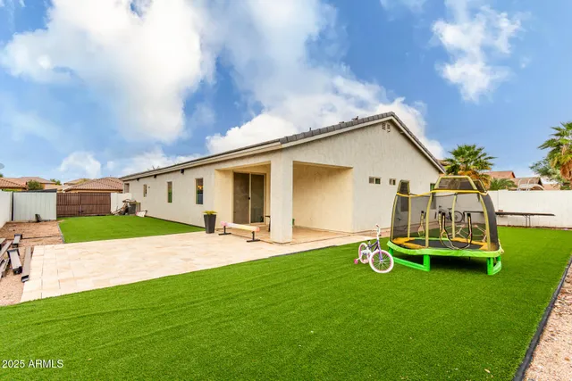 a backyard of a house with table and chairs