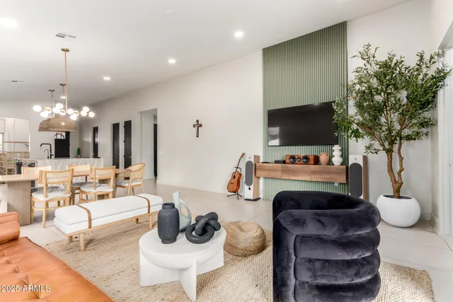 a living room with furniture a flat screen tv and a potted plant