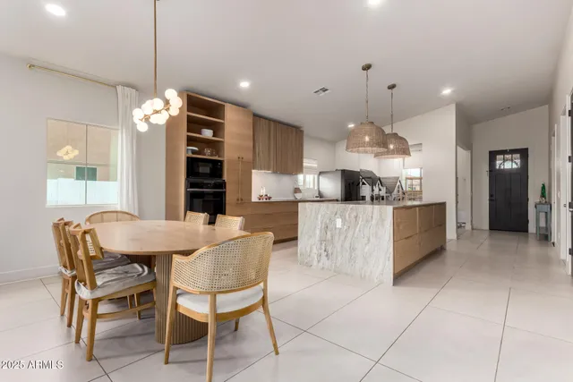 a kitchen with cabinets and chairs