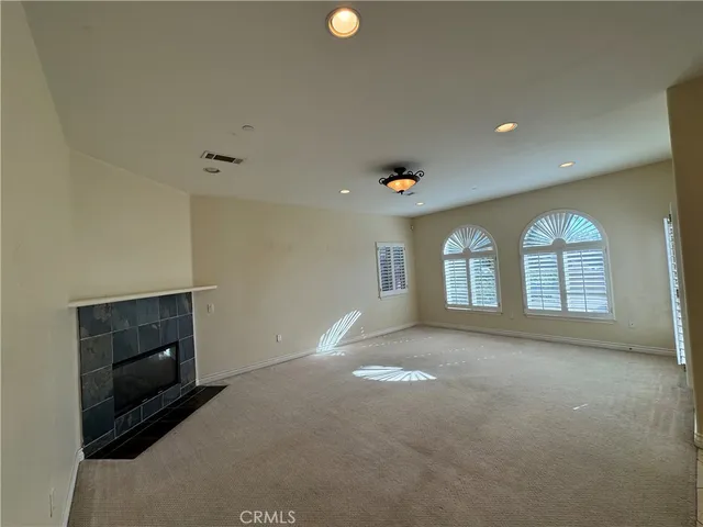 a view of empty room with windows and fireplace