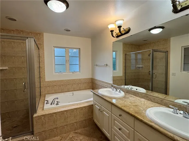 a bathroom with a granite countertop sink a large mirror and a bathtub