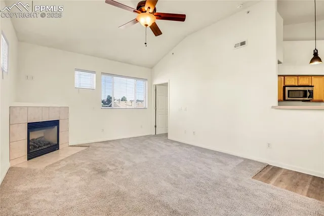 an empty room with fan and windows