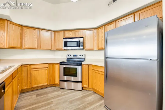 a kitchen with stainless steel appliances granite countertop white cabinets a stove and a sink