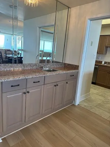 a spacious bathroom with a granite countertop sink a mirror and a vanity