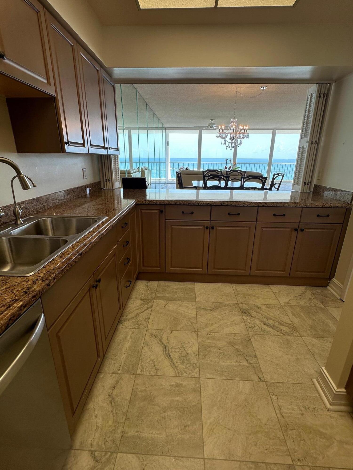 2001 Southeast Sailfish Point Boulevard, Unit 316 Stuart, FL 34996 - Photo 9 of 39 a kitchen with stainless steel appliances a sink a stove a microwave a sink and cabinets