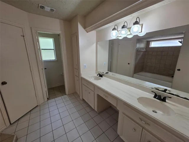 a bathroom with a double vanity sink mirror and shower