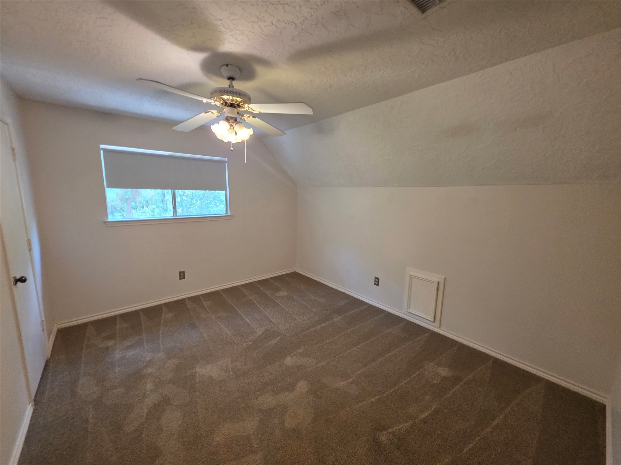 18 Mayfair Grove Court The Woodlands, TX 77381 - Photo 19 of 28 an empty room with a window and a chandelier fan