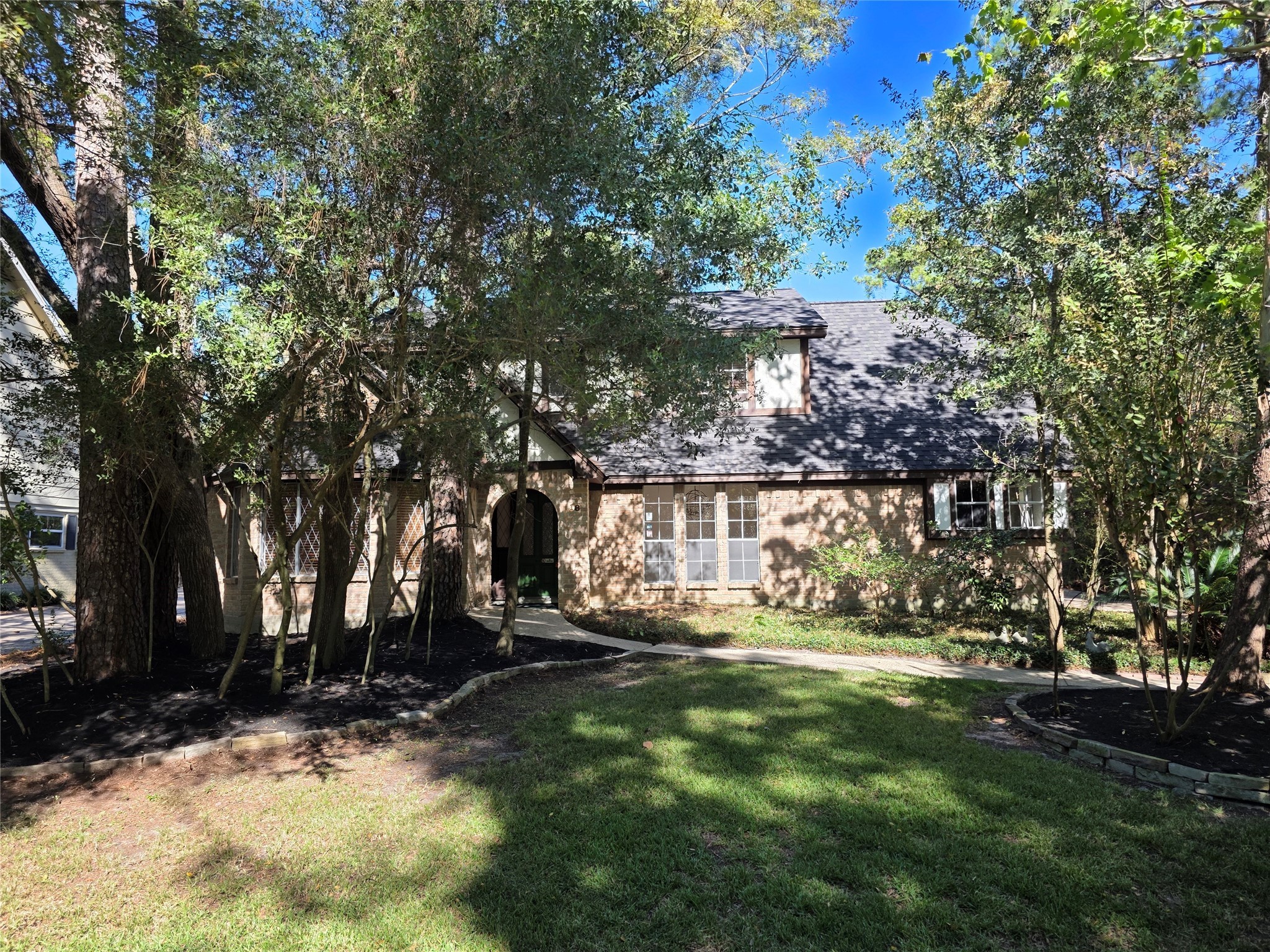 18 Mayfair Grove Court The Woodlands, TX 77381 - Photo 2 of 28 a view of outdoor space with garden and trees