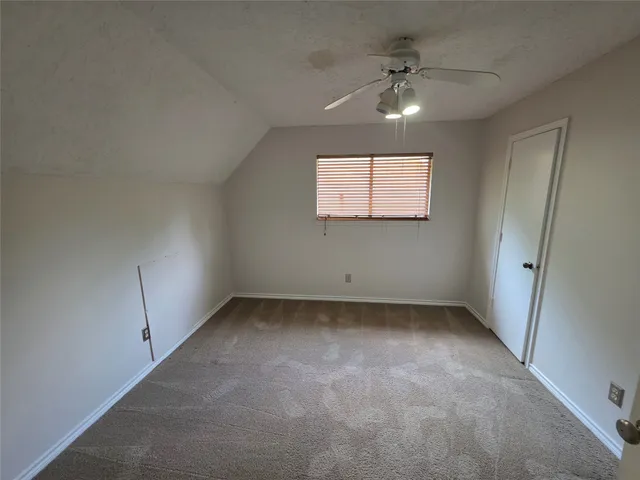 an empty room with a ceiling fan and window