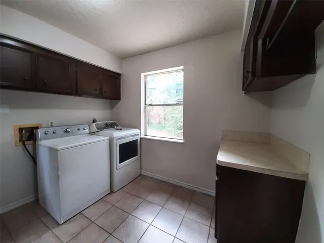 a utility room with cabinets washer and dryer