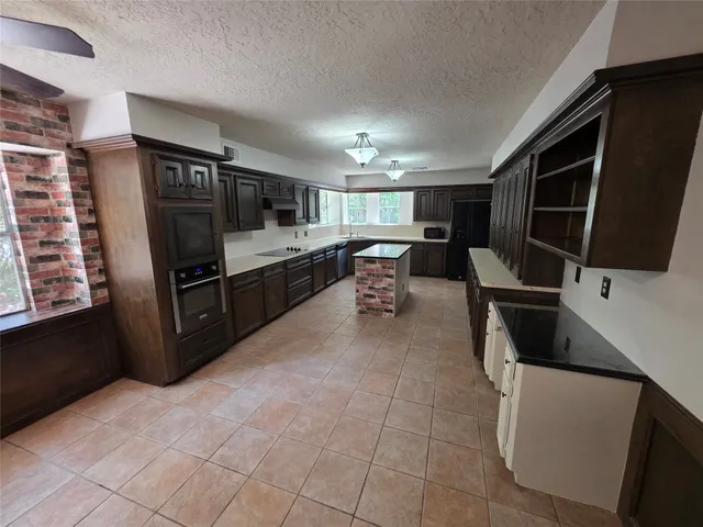 a living room with furniture a flat screen tv and kitchen view
