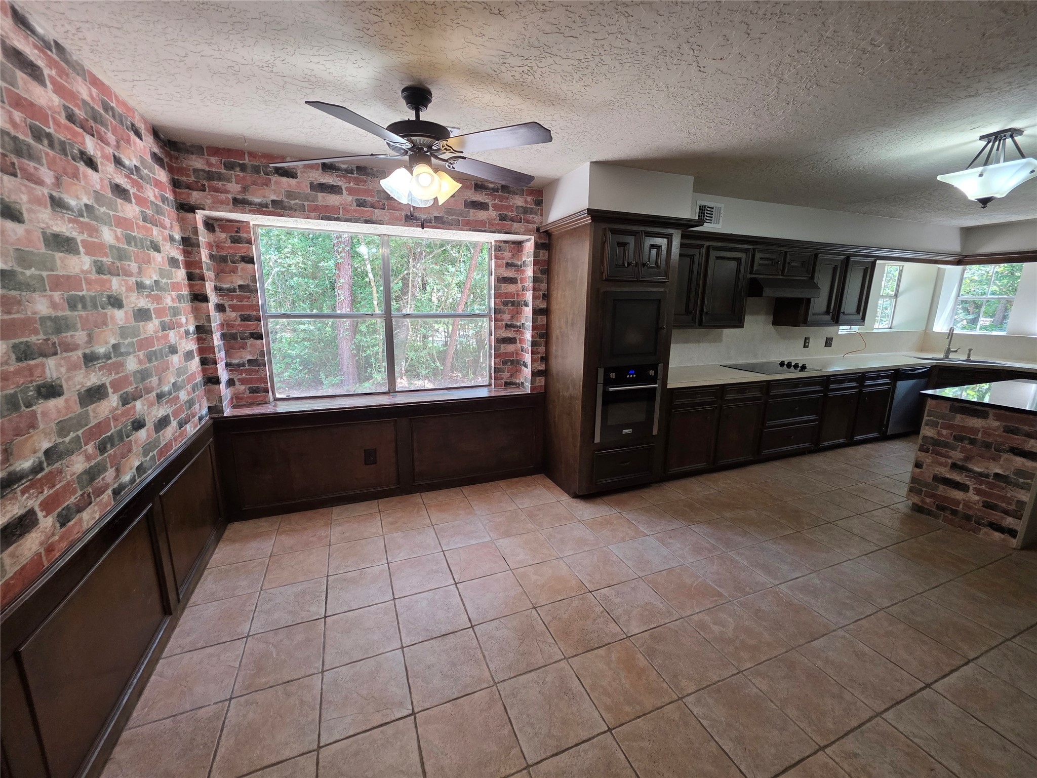 18 Mayfair Grove Court The Woodlands, TX 77381 - Photo 7 of 28 a large kitchen with granite countertop a stove a sink and a microwave