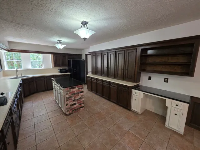 a kitchen with stainless steel appliances kitchen island granite countertop a sink and cabinets