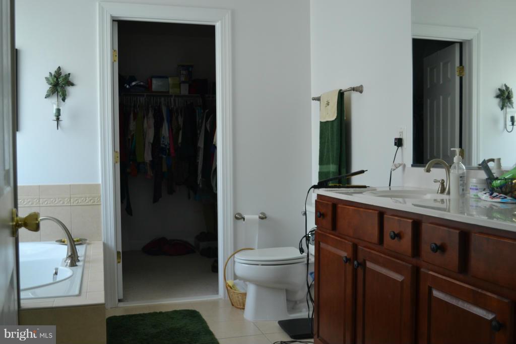 4145 Agency Loop Triangle, VA 22172 - Photo 18 of 24 a bathroom with a granite countertop sink a toilet and a shower