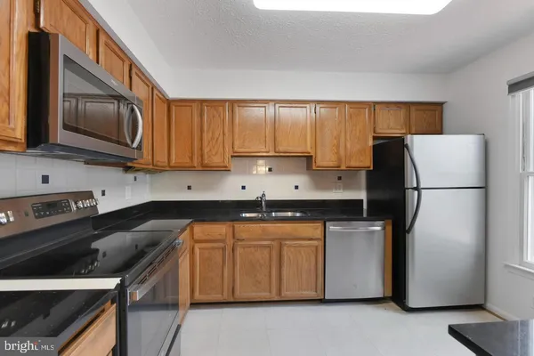 a kitchen with stainless steel appliances granite countertop a refrigerator stove a sink and dishwasher